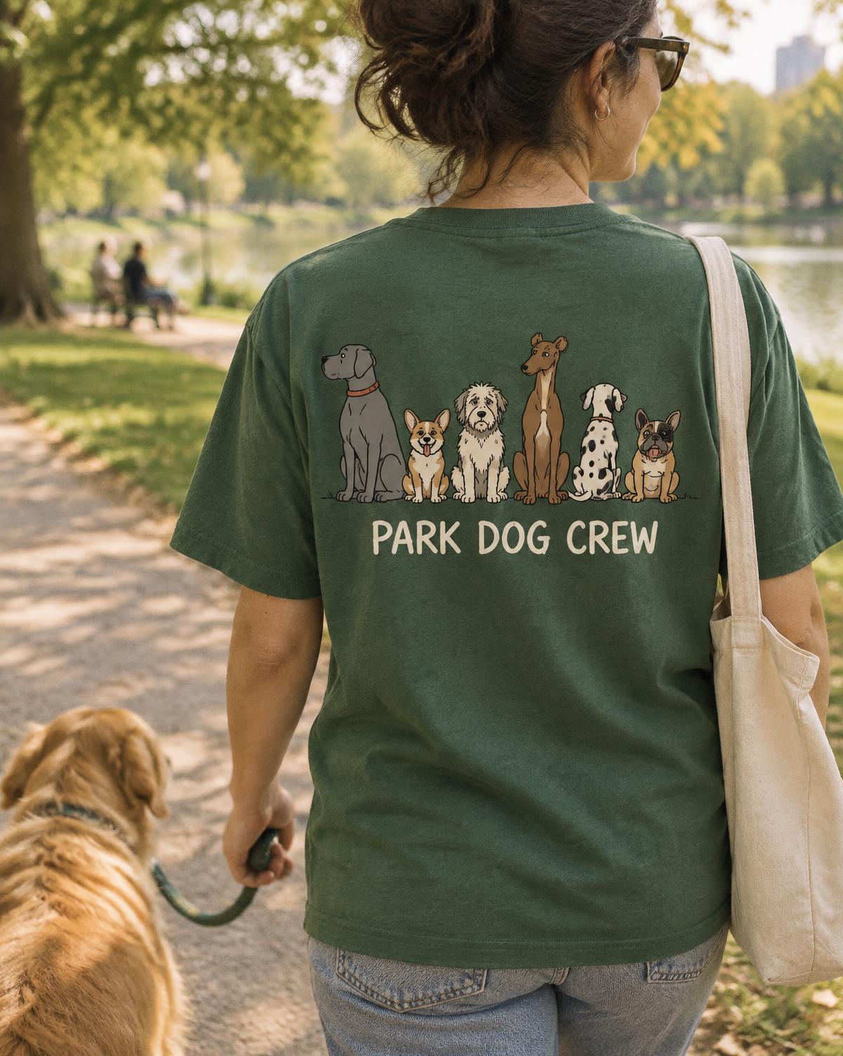 Woman walking a golden retriever in a green Park Dog Crew tee with a dog line-up printed on the back.