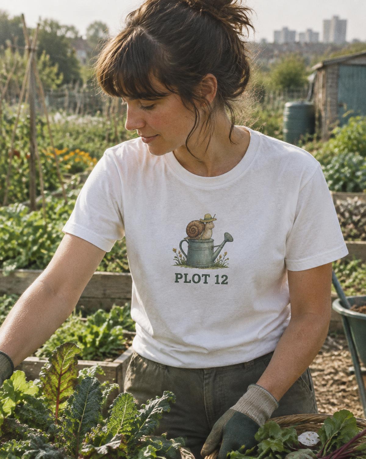 Woman weeding in a white Plot 12 tee printed with a snail in a gardener's hat on a watering can.