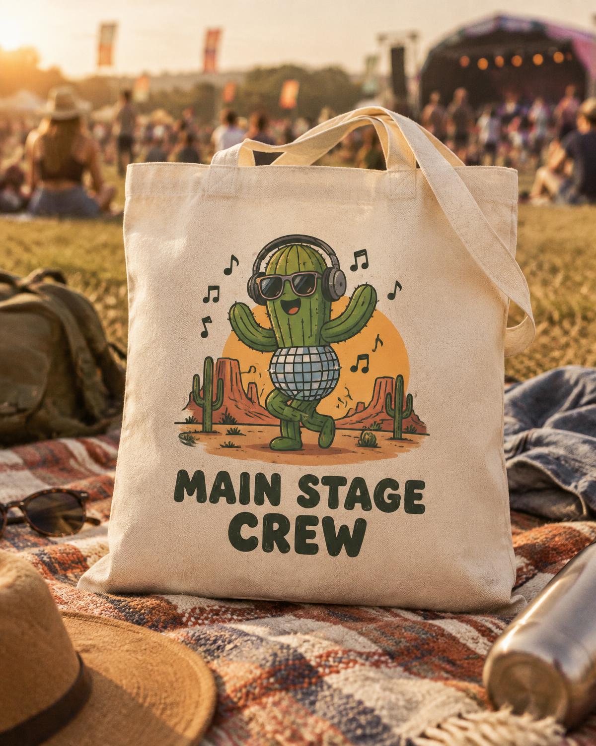 Natural tote with a dancing cactus in headphones and Main Stage Crew, on a blanket in a festival field.